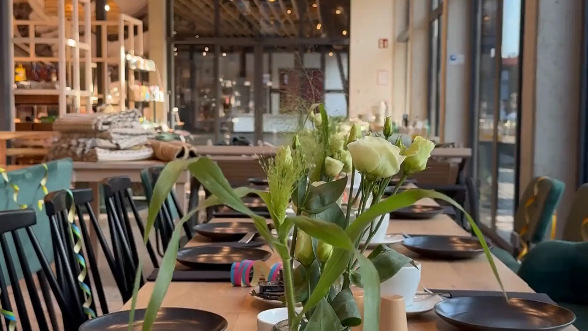 Lange, festlich gedeckte Tafel mit Blumen und Luftschlangen im Café Hofzeit